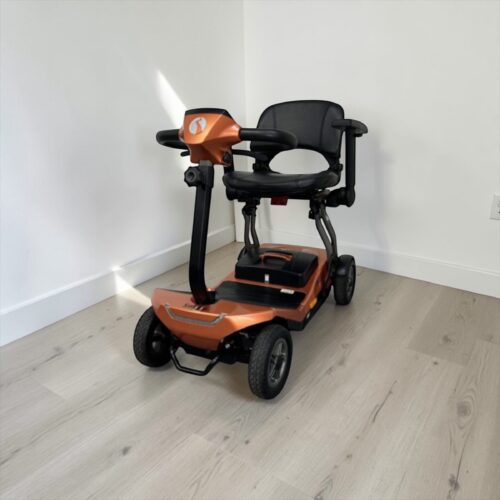 Photo showing a three-quarter view of the left of an Orange, Rascal Smilie Second hand mobility scooter.
