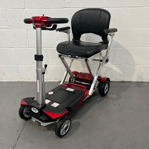 Three-quarter view of the left and front of a second-hand red and black CareCo Autofold Elite mobility scooter.