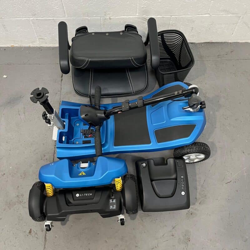 Overhead View of a Deconstructed Li-tech Neon 15 Mobility Scooter. the Image Shows the Scooter's 5 Main Components Laid out Separately: the High-backed Black Seat with Armrests is Detached and Placed Above the Scooter, the Tiller with Control Panel is in a Folded Position, and the Black Wire Basket is Adjacent to It. the Blue Base of the Scooter Houses the Battery Pack and Displays the Yellow Suspension Springs. a Detached Black Battery Case Labeled "li-tech" Sits Next to the Scooter Base. Li-tech Neon 15