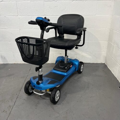Front and left side perspective of a Li-Tech Neon 15 mobility scooter. The scooter features a vibrant blue body with black accents, including a padded, black leatherette adjustable swivel seat with armrests and stitching details. It has a spacious black wire basket attached to the blue tiller. The front wheel has visible yellow suspension springs, and the scooter is equipped with solid black tires on silver rims.