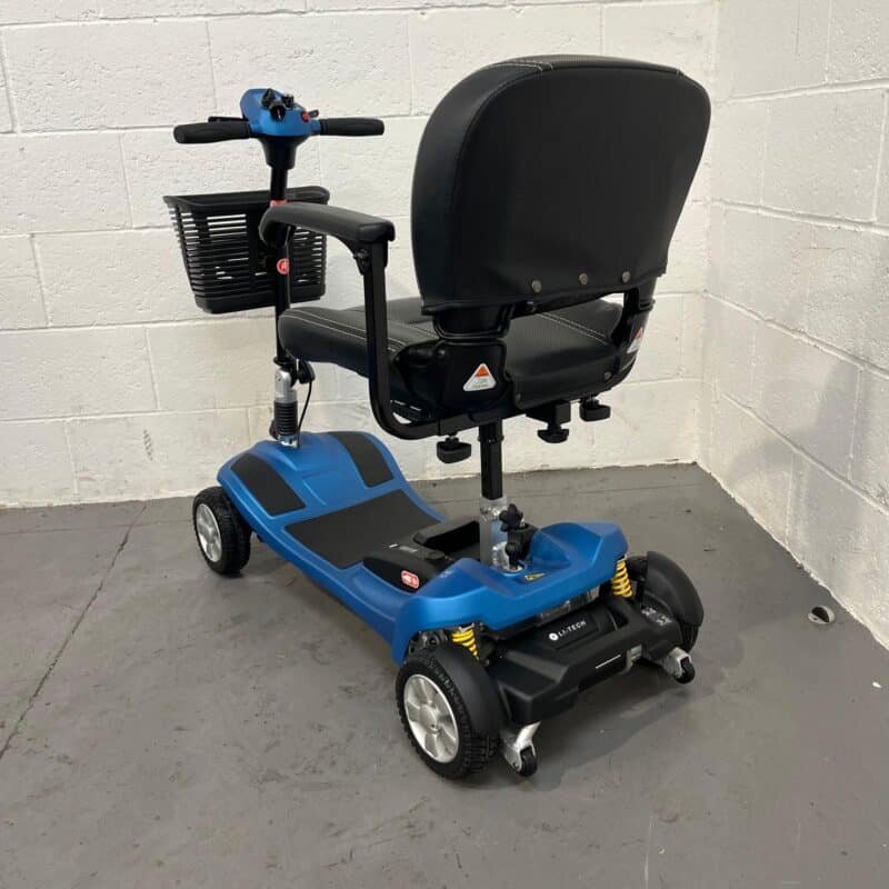 Rear and Left Side Perspective of a Li-tech Neon 15 Mobility Scooter. the Scooter Has a Bold Blue and Black Color Scheme, with an Adjustable Black Swivel Seat That Has a High Back and Headrest for Comfort. the Left Side Shows the Scooter's Control Tiller with a Black Wire Basket, Ergonomic Handle Grips, and the Control Panel with Red and Blue Buttons. the Scooter's Frame Has Yellow Shock Absorbers That Add a Pop of Color and Enhance the Vehicle's Suspension System. Li-tech Neon 15