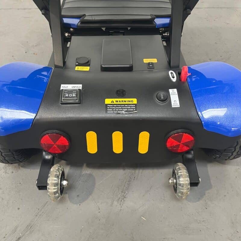 Closeup View of the Stability Wheels at the Rear of a Second-hand Blue Optimus Automatic Folding Mobility Scooter. Optimus Automatic Folding Scooter