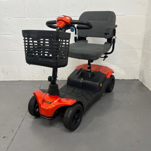 Three-quarter view of the left side and front of a orange and black and orange, 4mph transportable Abilize Stride Sport mobility scooter.