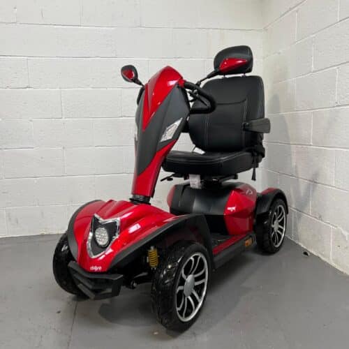 Three-quarter view of the left side and front of a red, 8mph road-legal Drive Cobra mobility scooter.