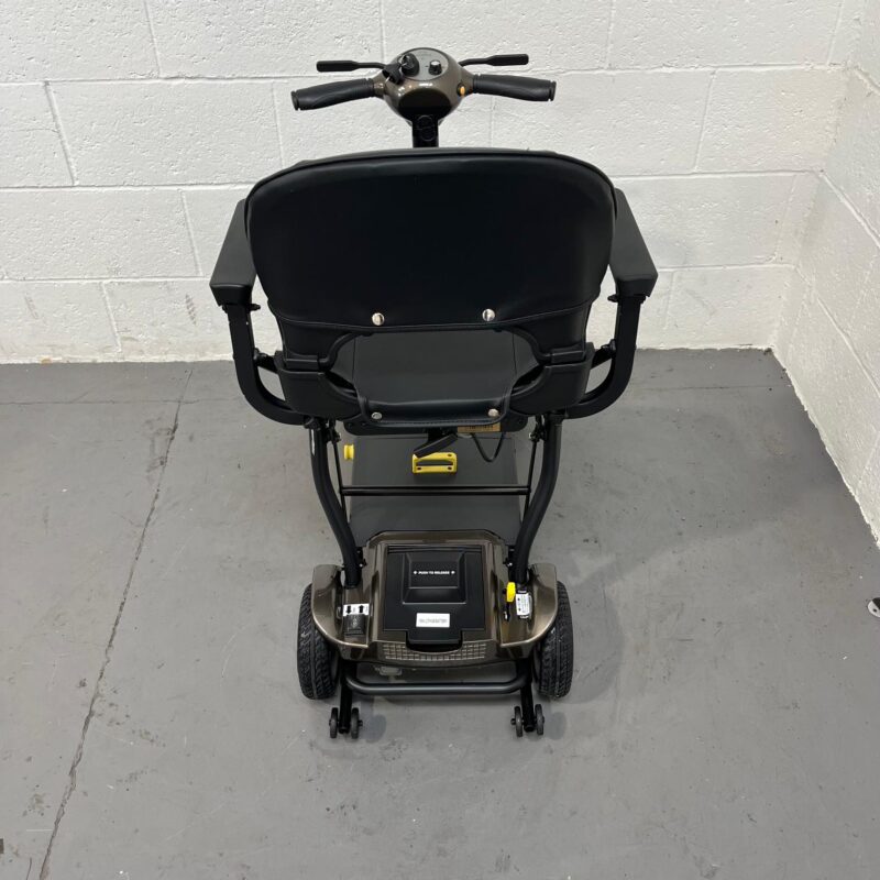 a View of the Rear of a Second-hand Gold and Black Globe Trotter Edrive Automatic Folding Mobility Scooter. One Rehab Globetrotter