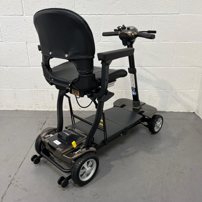 a Three Quarter View of the Rear and Right Side of a Second-hand Gold and Black Globe Trotter Edrive Automatic Folding Mobility Scooter. One Rehab Globetrotter