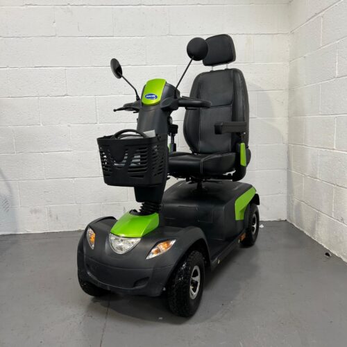 Three-quarter view of the left side and front of a green and black, 8mph, road-legal, second-hand Invacare Comet Pro mobility scooter.