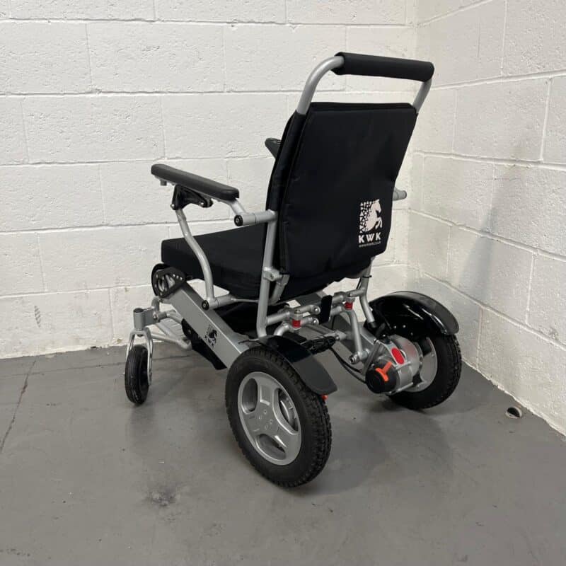 Three-quarter View of the Left Side and Rear of a Second-hand Silver and Black Kwk D09 Powerchair. Kwk D09 Powerchair