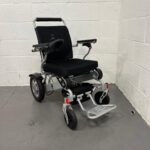 Three-quarter View of the Right Side and Front of a Second-hand Silver and Black Kwk D09 Powerchair. Kwk D09 Powerchair