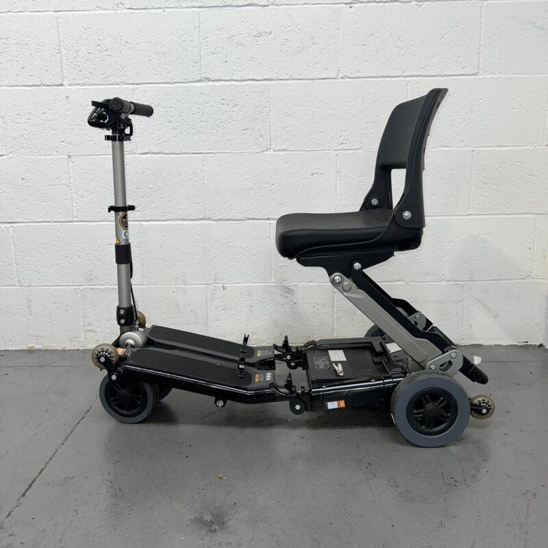 View of the Left Side of a Black 4mph Lightweight Folding Second-hand Luggie Mobility Scooter. Luggie Standard