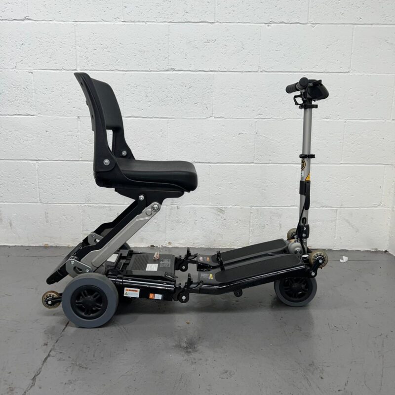 View of the Right Side of a Black 4mph Lightweight Folding Second-hand Luggie Mobility Scooter. Luggie Standard