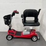 View of the Left-hand Side of a Second-hand Red One Rehab Illusion Transportable Mobility Scooter. the Seat Has Been Rotated 90 Degrees and Armrests Raised to Allow for Easy Mounting and Dismounting. One Rehab Illusion (red)