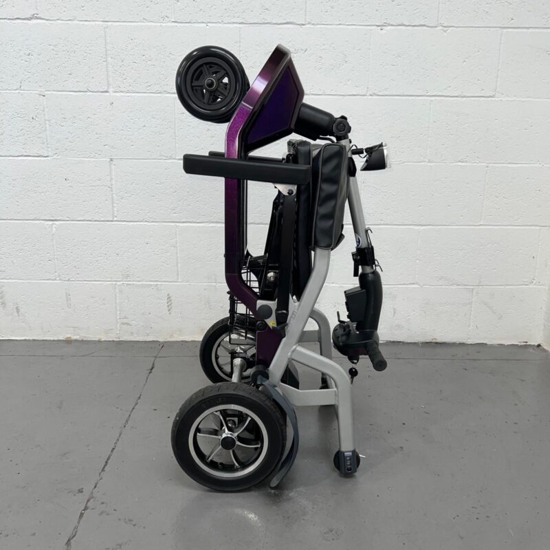 View of the Side of a Folded Purple 4mph Folding Second-hand One Rehab Q Fold Mobility Scooter. One Rehab Q Fold