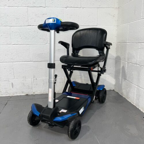 Three-quarter view of the left side and front of a blue 4mph automatic folding second-hand Solax Autofold mobility scooter.