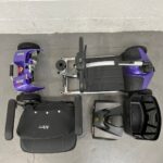 Photo of a Purple and Black, Motion Healthcare Evolite Second-hand Mobility Scooter, Deconstructed into 5 Parts for Easy Transportation. Motion Healthcare Evolite