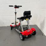 Photo Showing a Three-quarter View of the Left Side and Rear of a Red and Black, Motion Healthcare Mlite Second-hand Mobility Scooter. Motion Healthcare Mlite