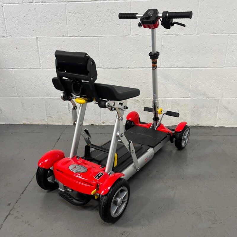 Photo Showing a Three-quarter View of the Right Side and Rear of a Red and Black, Motion Healthcare Mlite Second-hand Mobility Scooter. Motion Healthcare Mlite