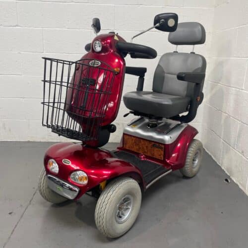 Photo showing a three-quarter view of the left side and front of a dark red Shoprider Cadiz Deluxe second-hand mobility scooter.